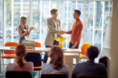 young business man is receiving congratulations from a employees